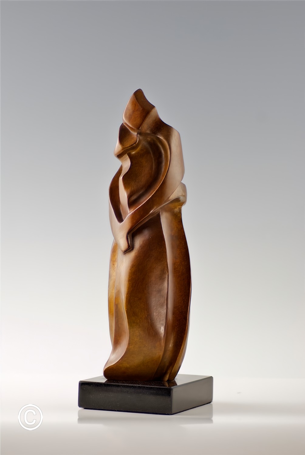 Love is an invisible force that fuses us together. It is the only time we feel safe.  We have all experienced being immersed, or lost, in love.
We see a hand, or an arm, or an elbow forming, as the essence of Embrace emerges, losing itself in “oneness”.
We are invited into the world of lovers sharing an intimate moment.  Where one lover begins and the other ends, is as mysterious as the Embrace itself.
